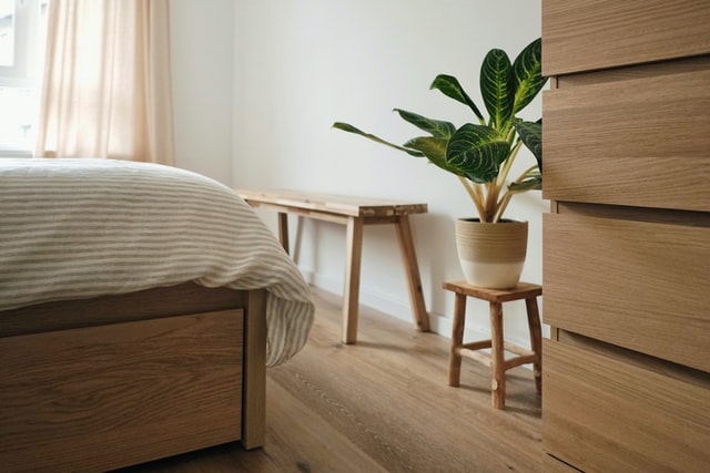 bed corner with plant on a little table